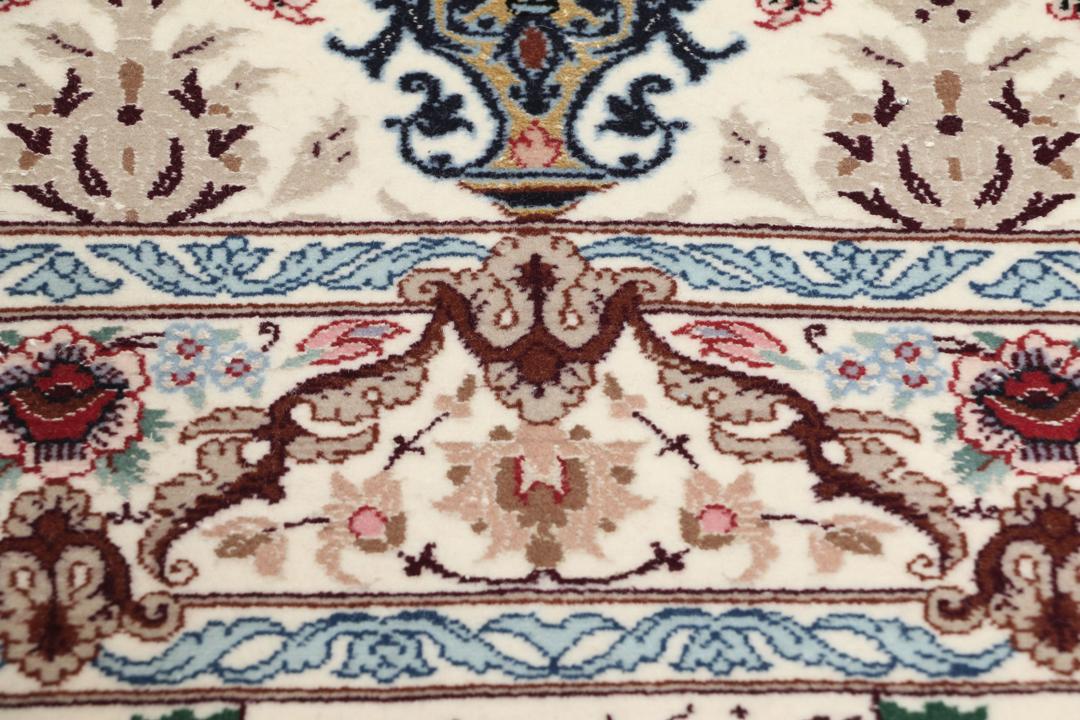 Håndknyttet Isfahan-tæppe fra Mellemøsten med blomstermotiver i beige, blå og rød.