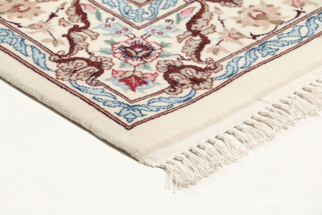 Håndknyttet Isfahan-tæppe fra Mellemøsten med blomstermotiver i beige, blå og rød.
