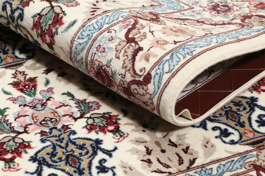 Håndknyttet Isfahan-tæppe fra Mellemøsten med blomstermotiver i beige, blå og rød.