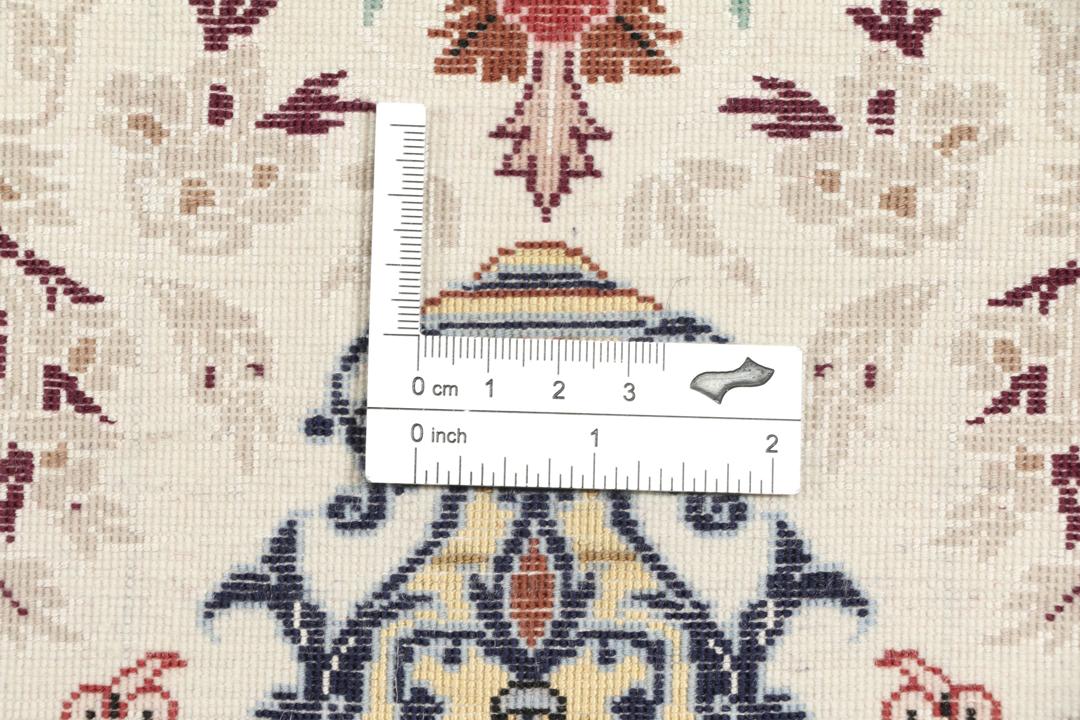 Håndknyttet Isfahan-tæppe fra Mellemøsten med blomstermotiver i beige, blå og rød.