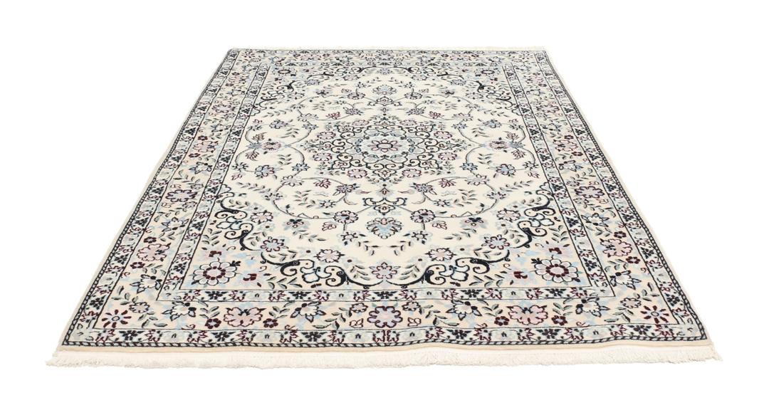 Handgeknoopt Nain tapijt uit het Midden-Oosten met ingewikkelde bloemmotieven in beige en blauw.