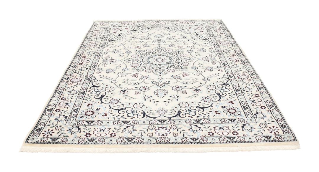 Handgeknoopt Nain tapijt uit het Midden-Oosten met ingewikkelde bloemmotieven in beige en blauw.