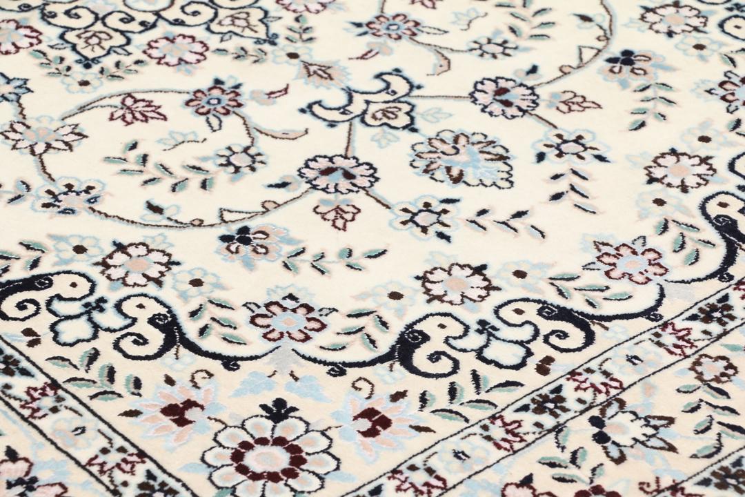 Handgeknoopt Nain tapijt uit het Midden-Oosten met ingewikkelde bloemmotieven in beige en blauw.