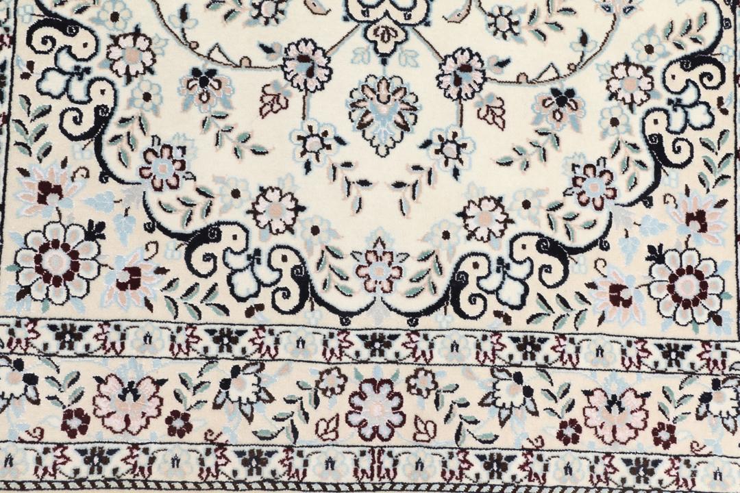 Handgeknoopt Nain tapijt uit het Midden-Oosten met ingewikkelde bloemmotieven in beige en blauw.