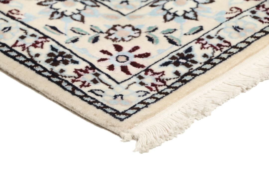 Handgeknoopt Nain tapijt uit het Midden-Oosten met ingewikkelde bloemmotieven in beige en blauw.