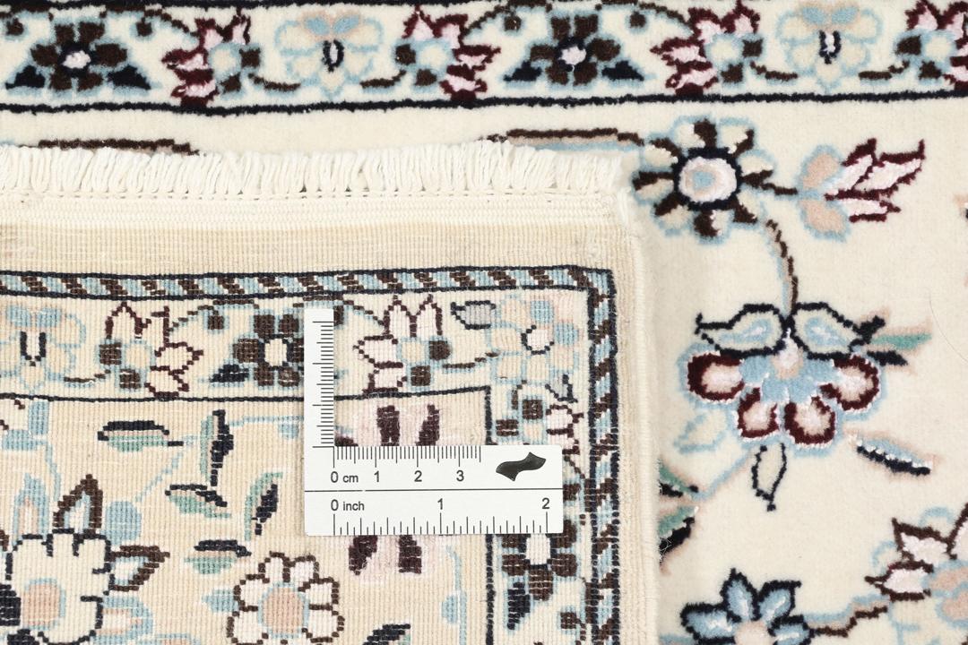 Handgeknoopt Nain tapijt uit het Midden-Oosten met ingewikkelde bloemmotieven in beige en blauw.