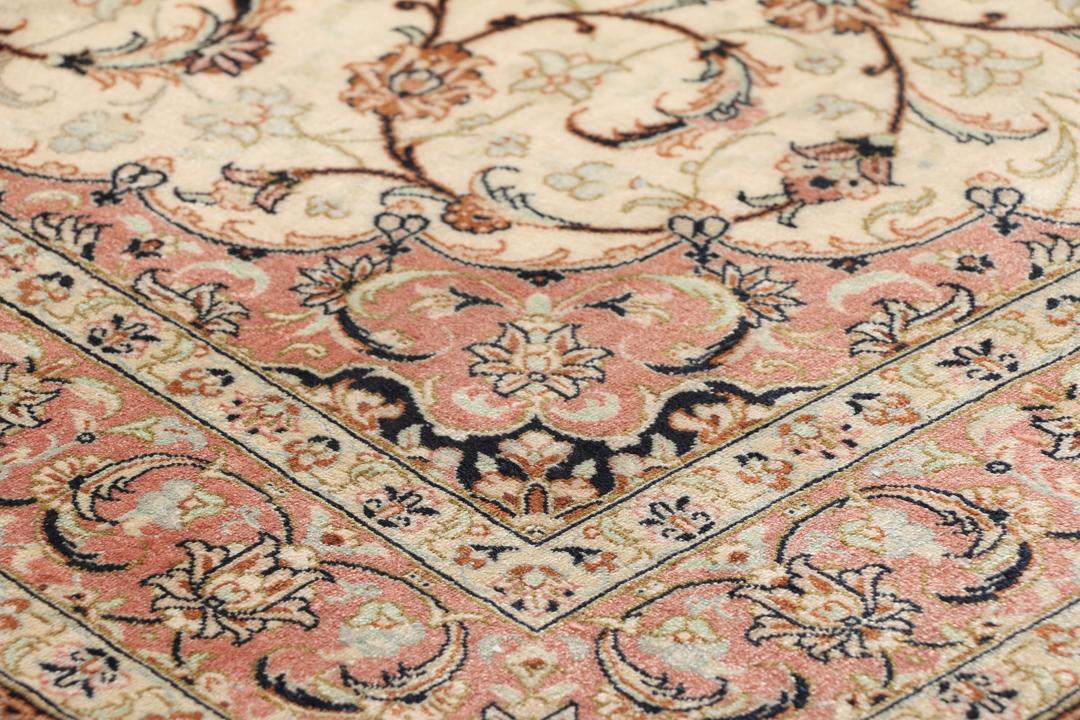 Een luxueus handgeknoopt Qum zijden tapijt uit het Midden-Oosten met een beige veld en bloemmotieven