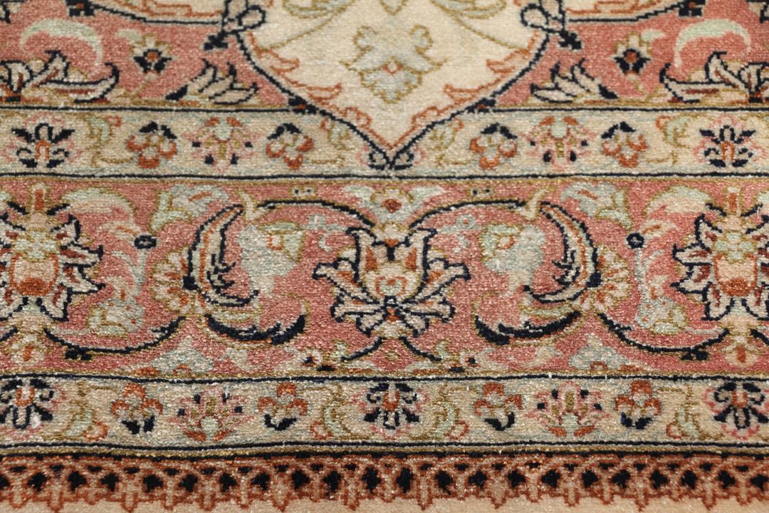 Een luxueus handgeknoopt Qum zijden tapijt uit het Midden-Oosten met een beige veld en bloemmotieven