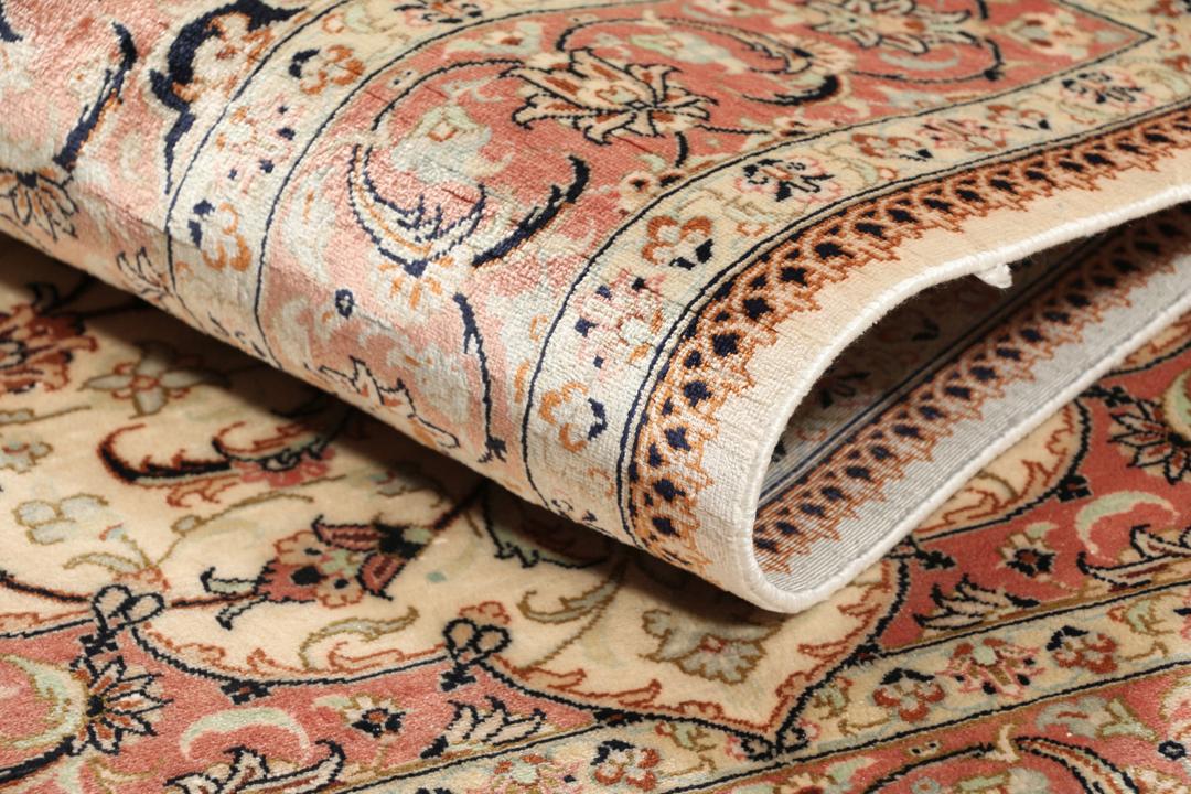 Een luxueus handgeknoopt Qum zijden tapijt uit het Midden-Oosten met een beige veld en bloemmotieven