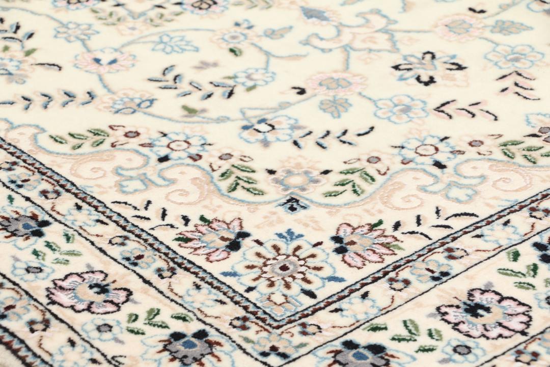 Een handgeknoopt Nain-tapijt uit het Midden-Oosten met een beige achtergrond en bloempatronen.
