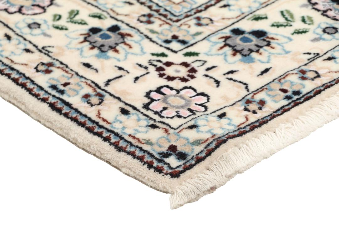 Een handgeknoopt Nain-tapijt uit het Midden-Oosten met een beige achtergrond en bloempatronen.