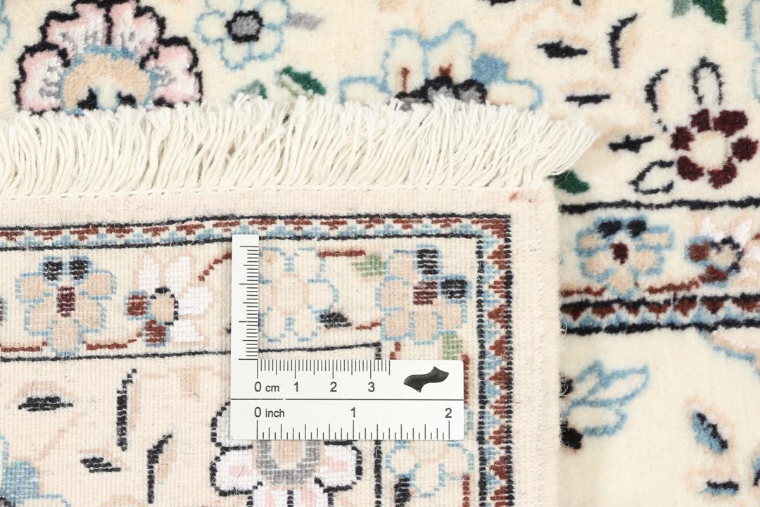Een handgeknoopt Nain-tapijt uit het Midden-Oosten met een beige achtergrond en bloempatronen.