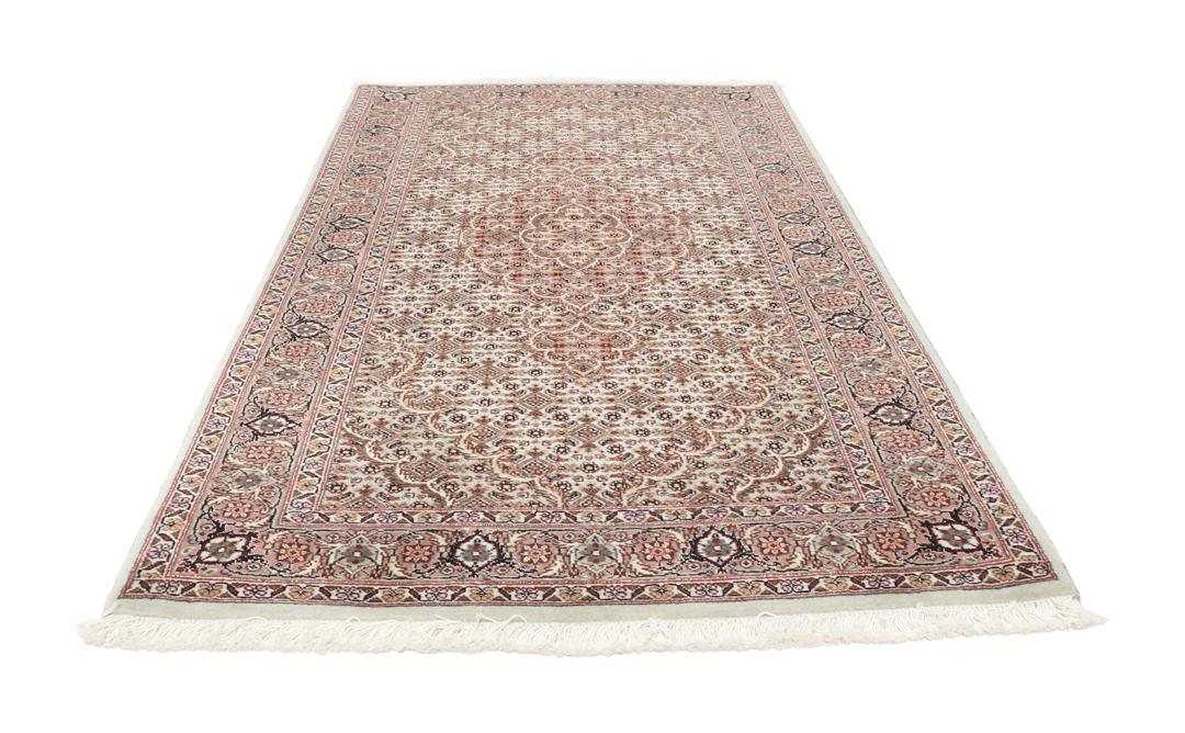 Håndknyttet Tabriz-tæppe med indviklede blomstermedallionmønstre i røde og beige toner.