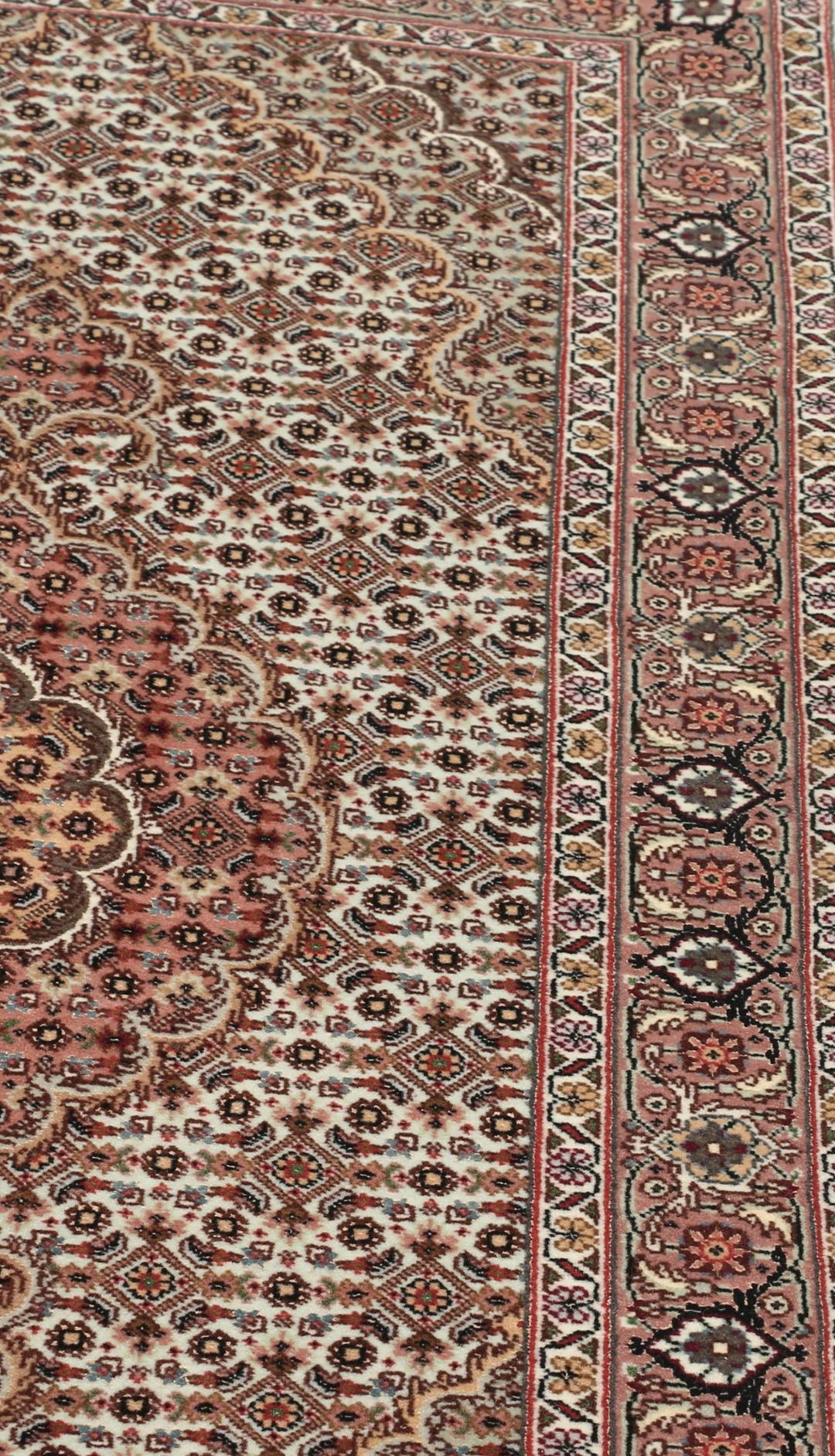 Håndknyttet Tabriz-tæppe med indviklede blomstermedallionmønstre i røde og beige toner.