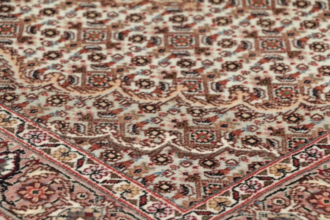 Håndknyttet Tabriz-tæppe med indviklede blomstermedallionmønstre i røde og beige toner.
