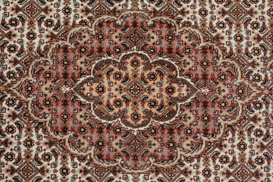 Håndknyttet Tabriz-tæppe med indviklede blomstermedallionmønstre i røde og beige toner.