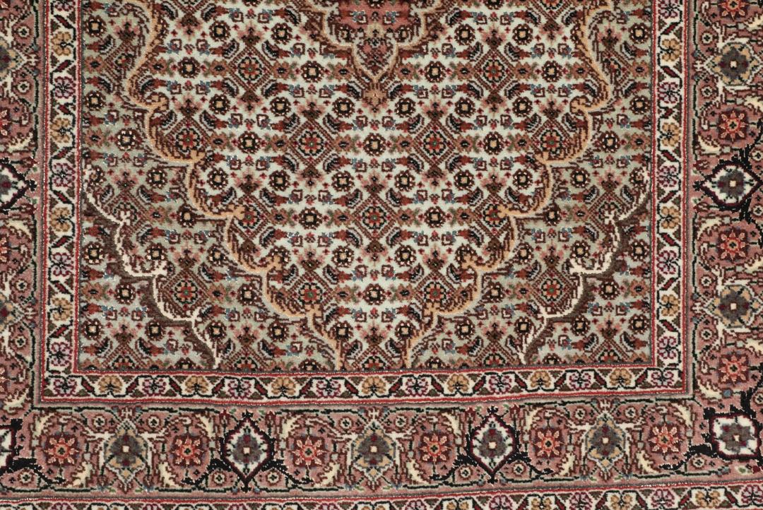 Håndknyttet Tabriz-tæppe med indviklede blomstermedallionmønstre i røde og beige toner.