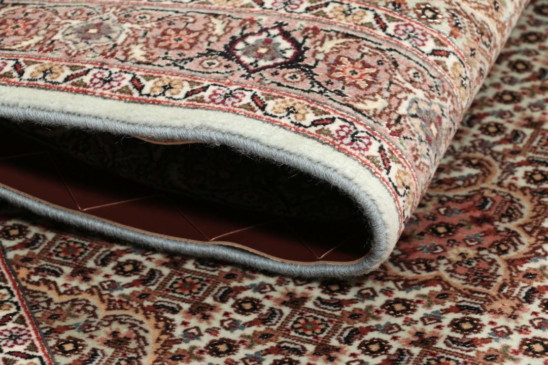 Håndknyttet Tabriz-tæppe med indviklede blomstermedallionmønstre i røde og beige toner.