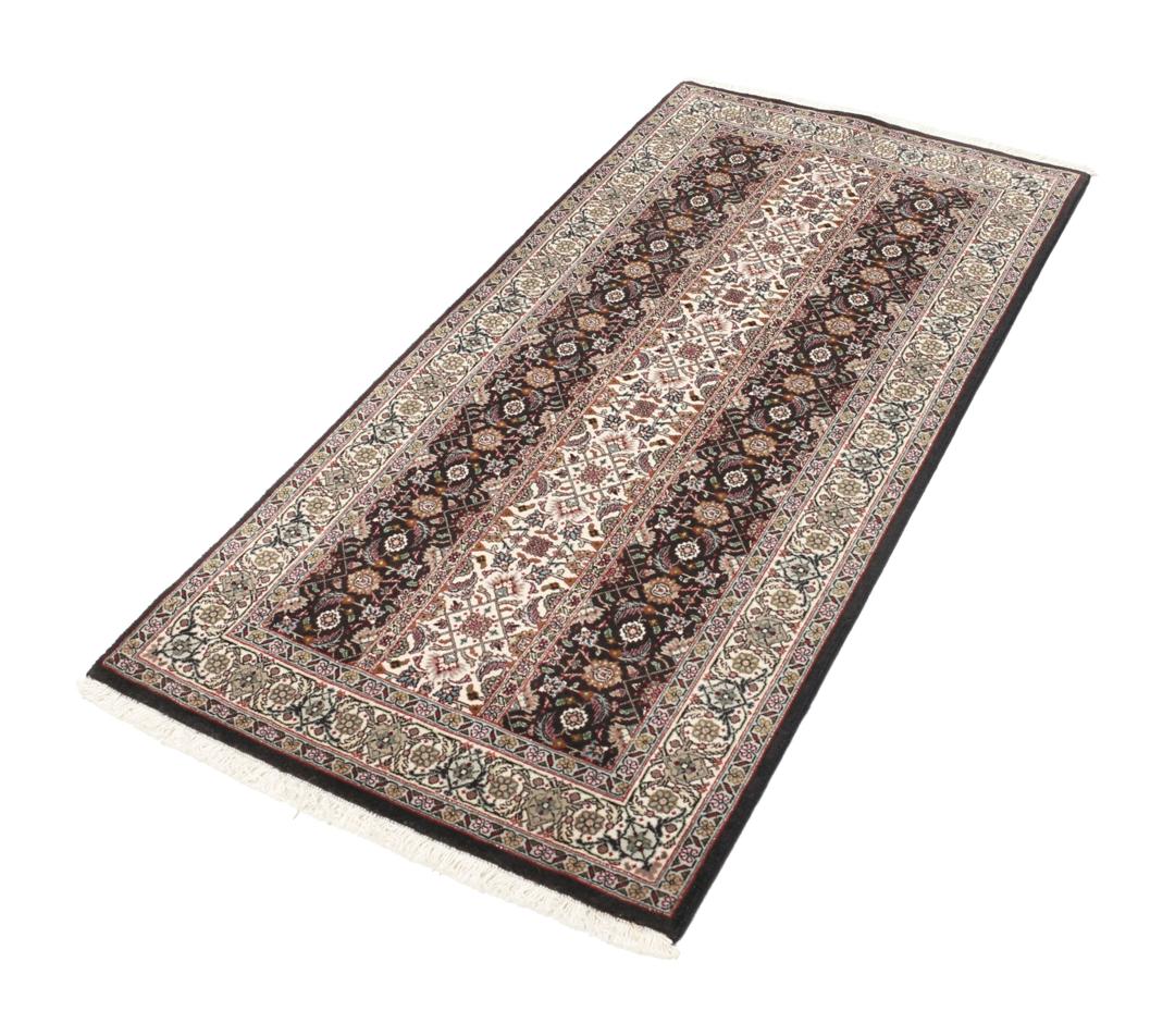 Et rektangulært Tabriz-tæppe fra Mellemøsten med et mørkt, flerfarvet blomsterdesign.
