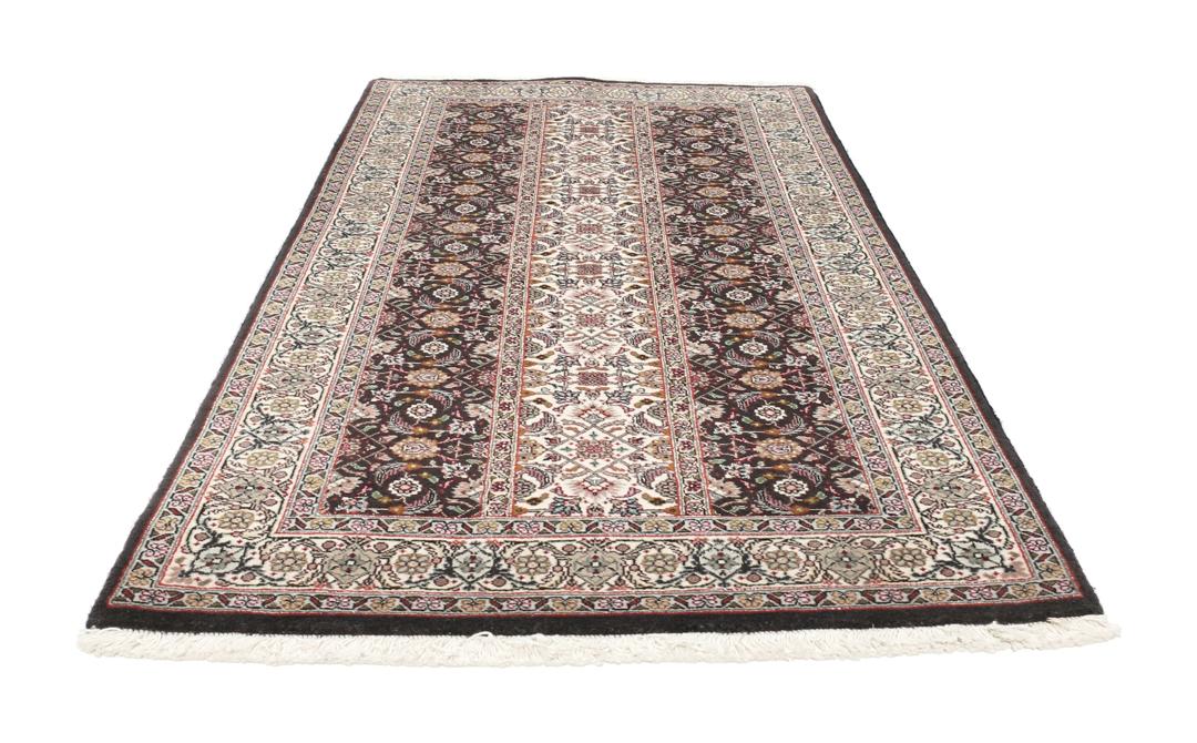 Et rektangulært Tabriz-tæppe fra Mellemøsten med et mørkt, flerfarvet blomsterdesign.
