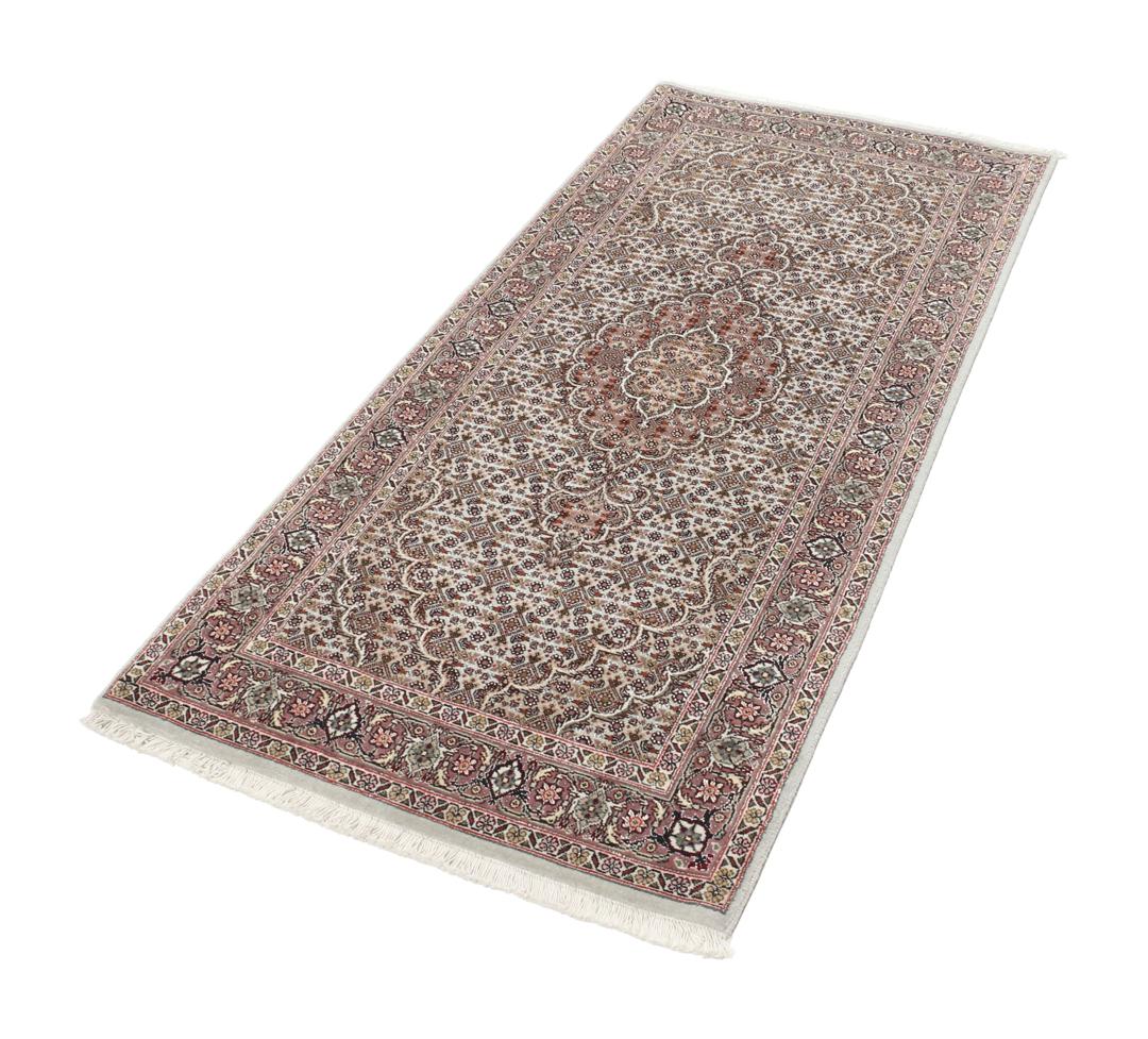 Et håndknyttet Tabriz-tæppe fra Mellemøsten med et rødt og beige blomster-medaljondesign.