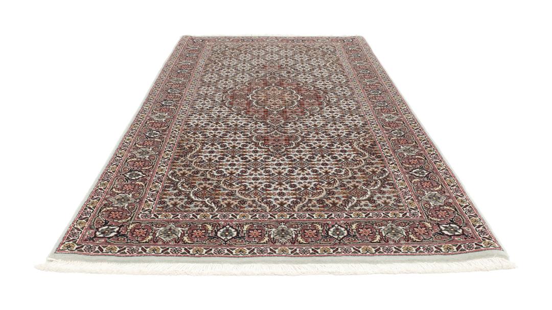 Et håndknyttet Tabriz-tæppe fra Mellemøsten med et rødt og beige blomster-medaljondesign.