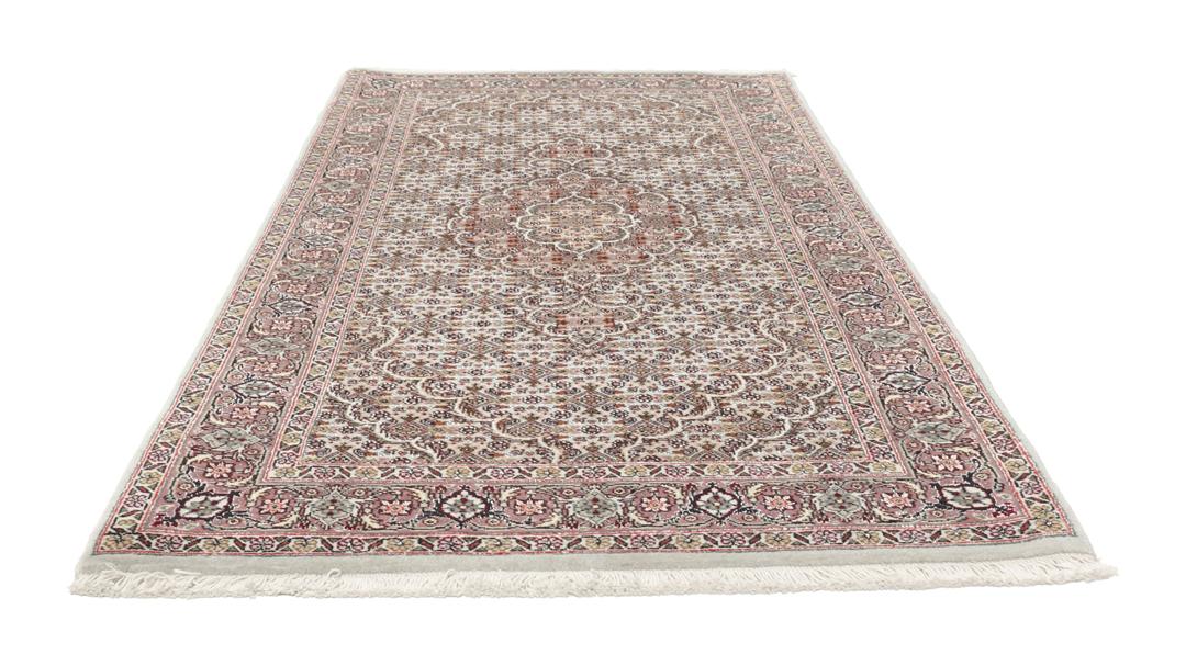 Et håndknyttet Tabriz-tæppe fra Mellemøsten med et rødt og beige blomster-medaljondesign.