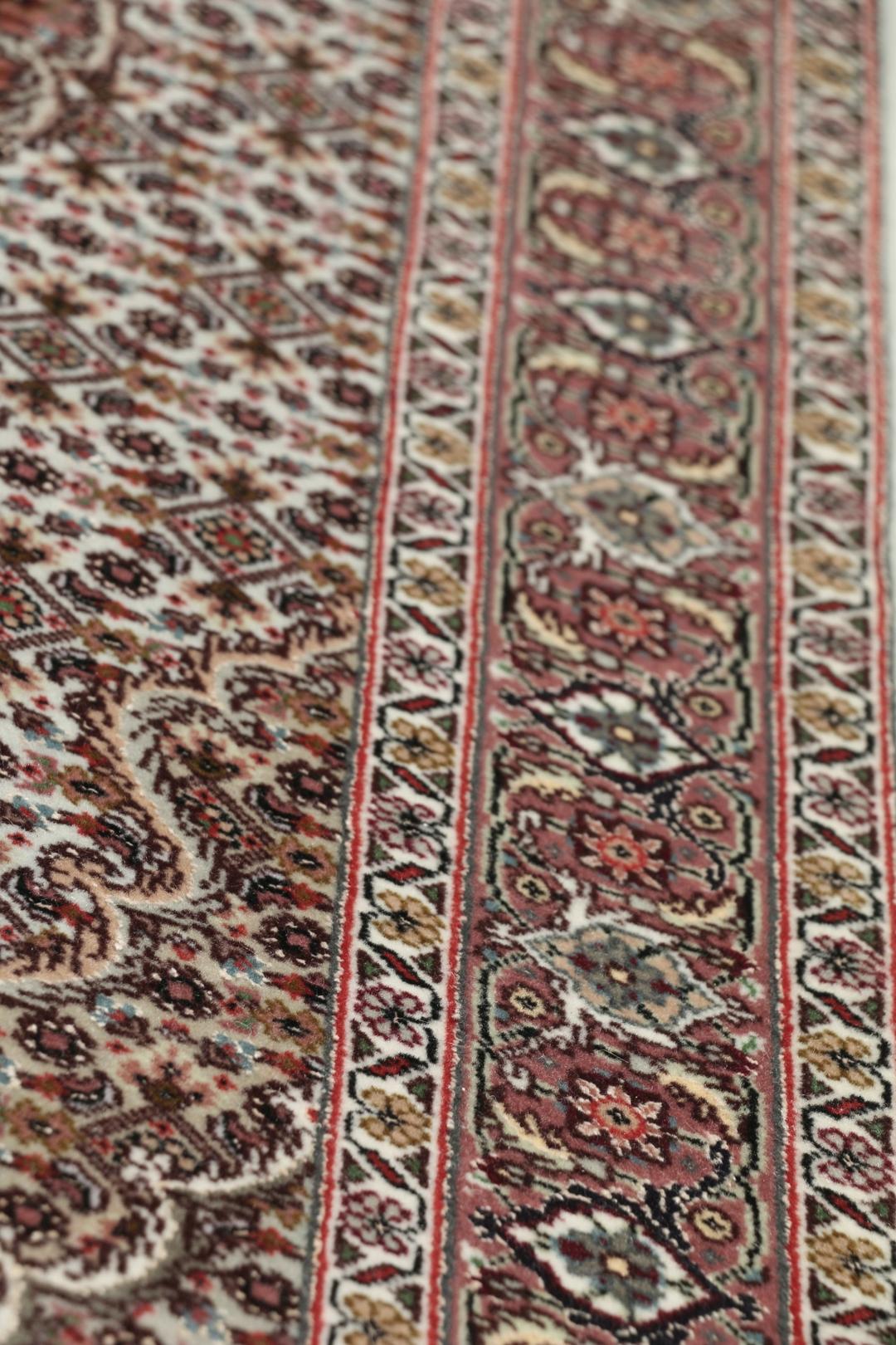 Et håndknyttet Tabriz-tæppe fra Mellemøsten med et rødt og beige blomster-medaljondesign.