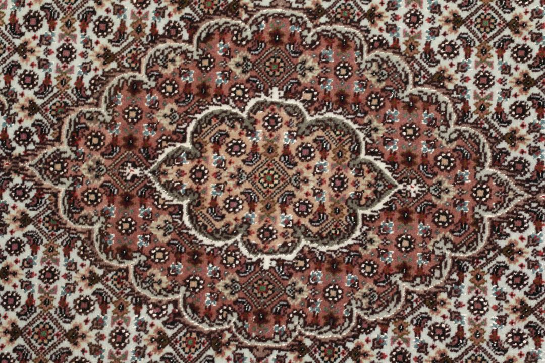 Et håndknyttet Tabriz-tæppe fra Mellemøsten med et rødt og beige blomster-medaljondesign.