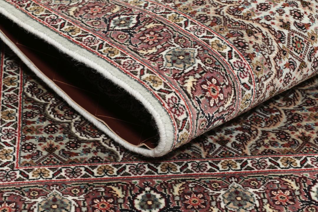 Et håndknyttet Tabriz-tæppe fra Mellemøsten med et rødt og beige blomster-medaljondesign.