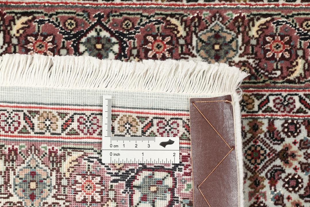 Et håndknyttet Tabriz-tæppe fra Mellemøsten med et rødt og beige blomster-medaljondesign.