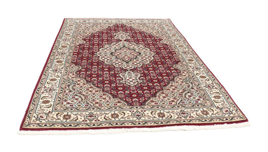 Et håndknyttet Tabriz 50 Raj-tæppe fra Mellemøsten med et levende rødt felt.