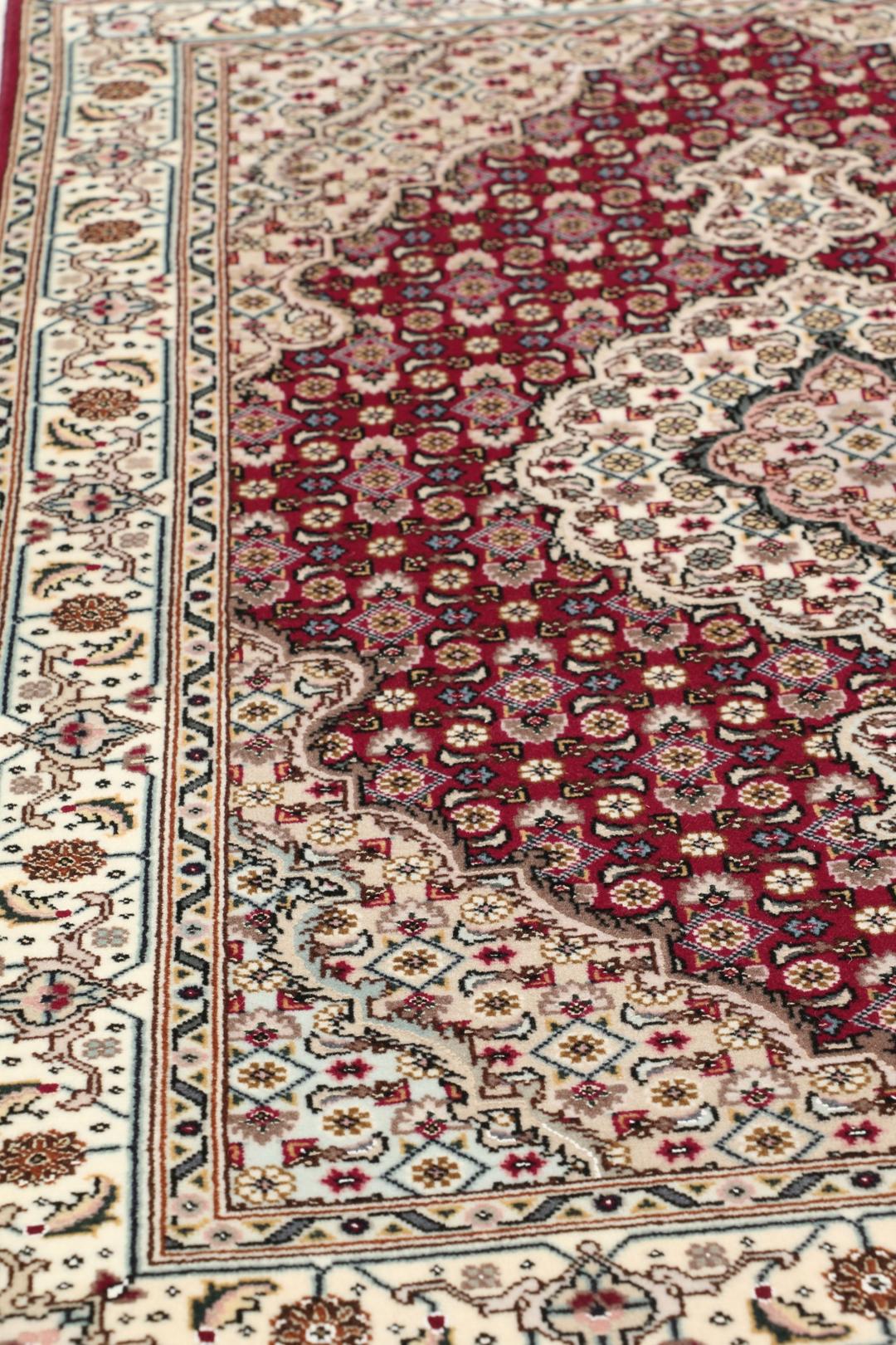 Et håndknyttet Tabriz 50 Raj-tæppe fra Mellemøsten med et levende rødt felt.
