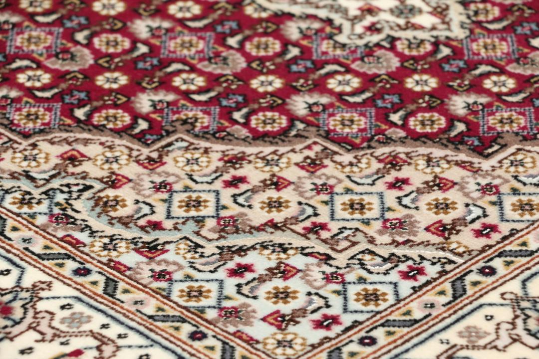 Et håndknyttet Tabriz 50 Raj-tæppe fra Mellemøsten med et levende rødt felt.