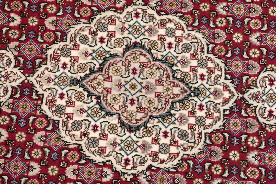Et håndknyttet Tabriz 50 Raj-tæppe fra Mellemøsten med et levende rødt felt.