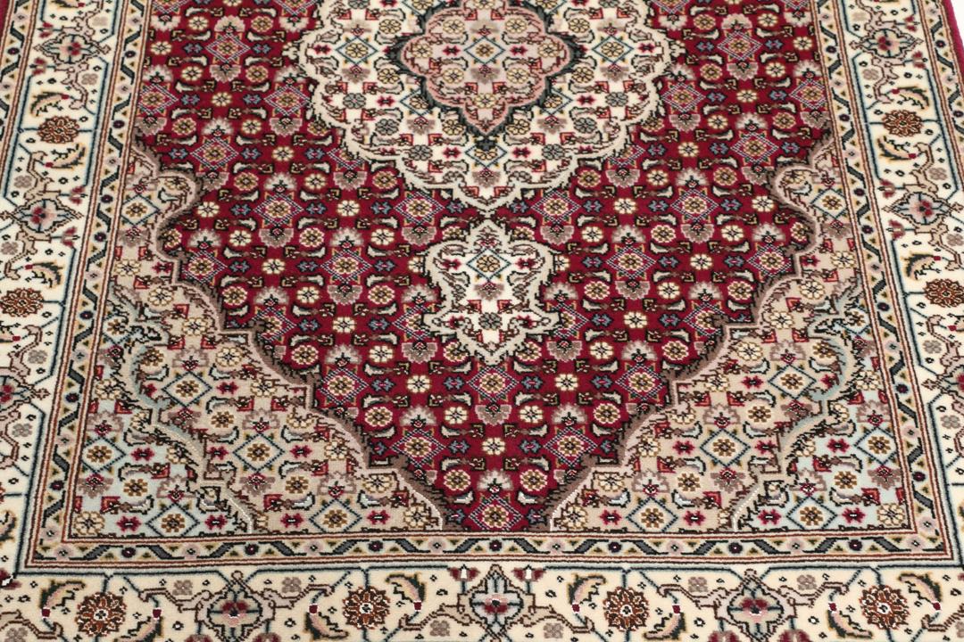 Et håndknyttet Tabriz 50 Raj-tæppe fra Mellemøsten med et levende rødt felt.