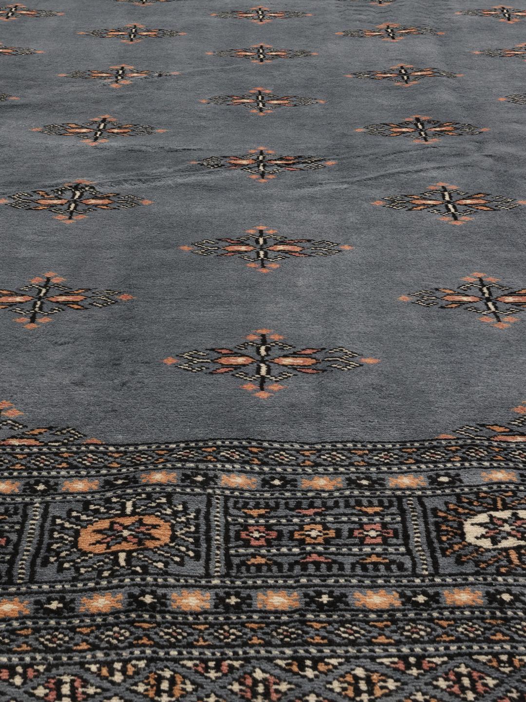 Een vierkant Pakistan Bokhara 2-ply handgeknoopt tapijt in grijs met traditionele herhalende motieven.