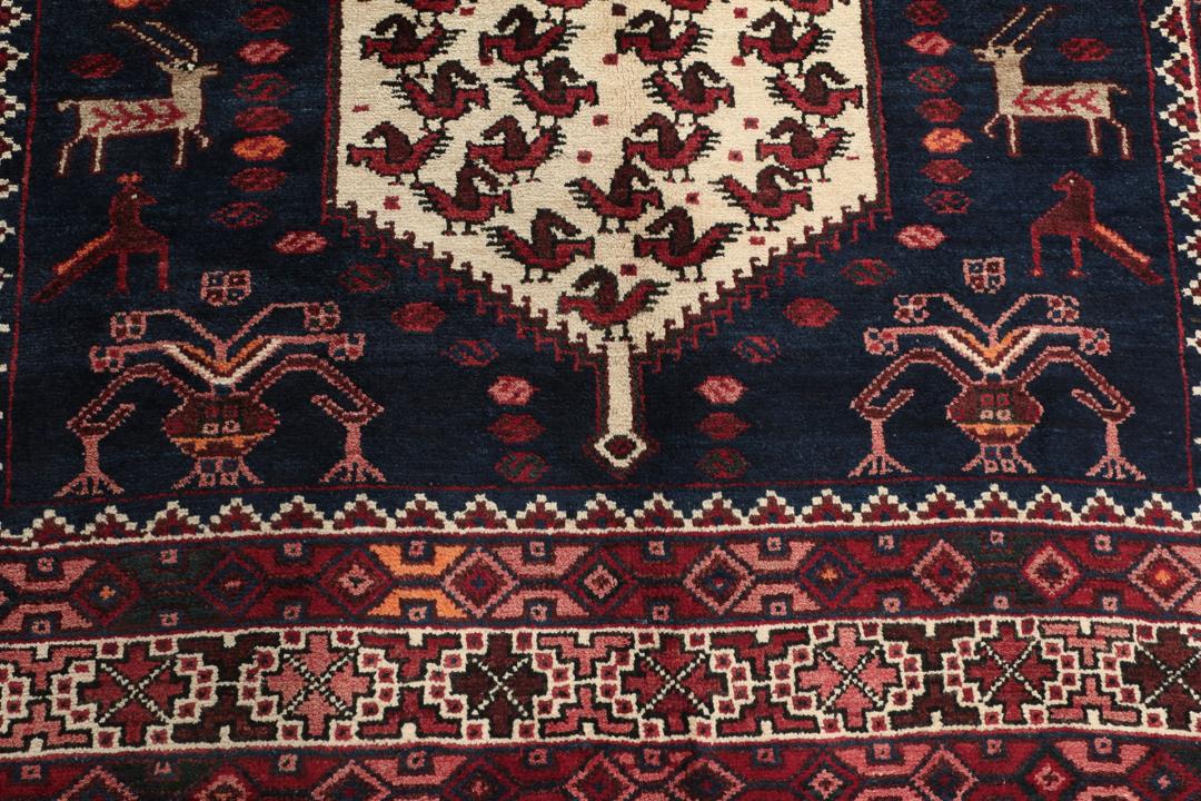 Een uniek, met de hand geknoopt Kurdi Ghuchan tapijt uit het Midden-Oosten met een donkerblauw veld en gedetailleerde diermotieven.