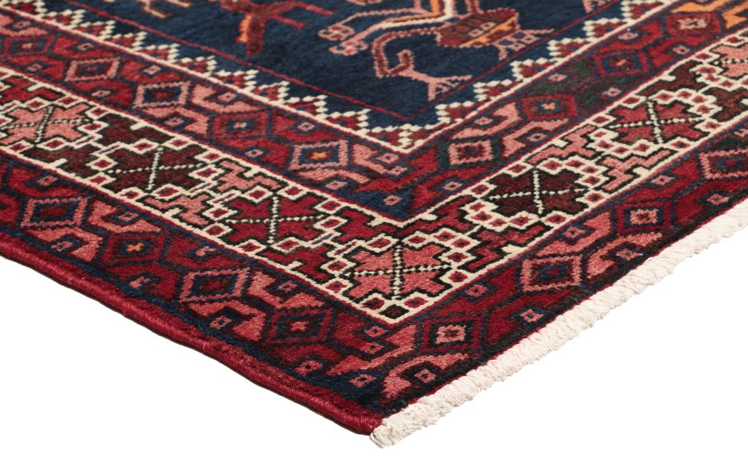Een uniek, met de hand geknoopt Kurdi Ghuchan tapijt uit het Midden-Oosten met een donkerblauw veld en gedetailleerde diermotieven.