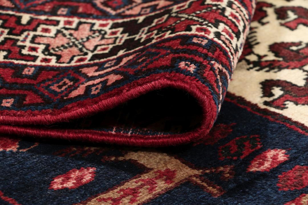 Een uniek, met de hand geknoopt Kurdi Ghuchan tapijt uit het Midden-Oosten met een donkerblauw veld en gedetailleerde diermotieven.