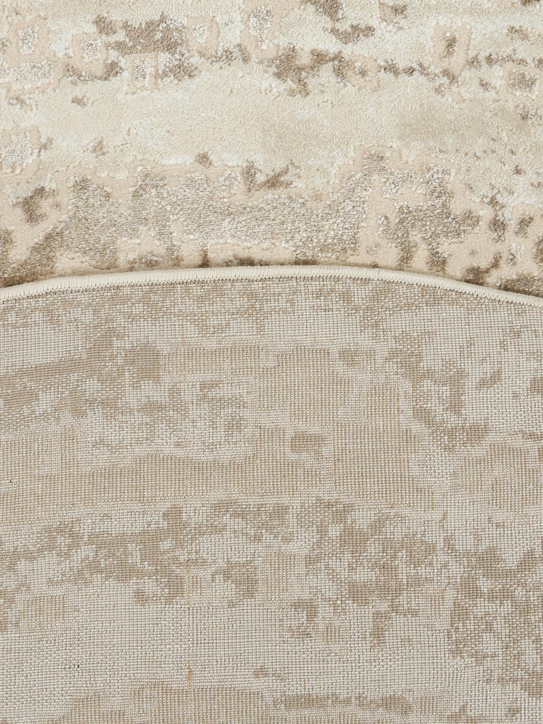 Rundt lyst beige tæppe med struktureret mønster