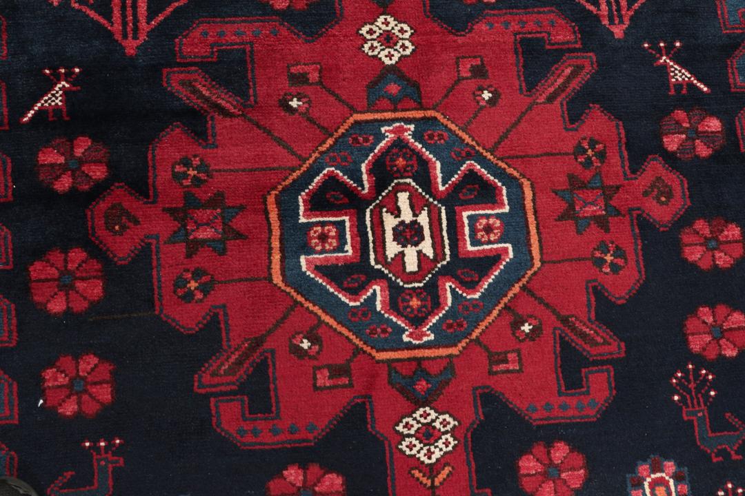 Een handgeknoopt Zanjan-tapijt uit het Midden-Oosten met een dieprood en zwart geometrisch ontwerp.