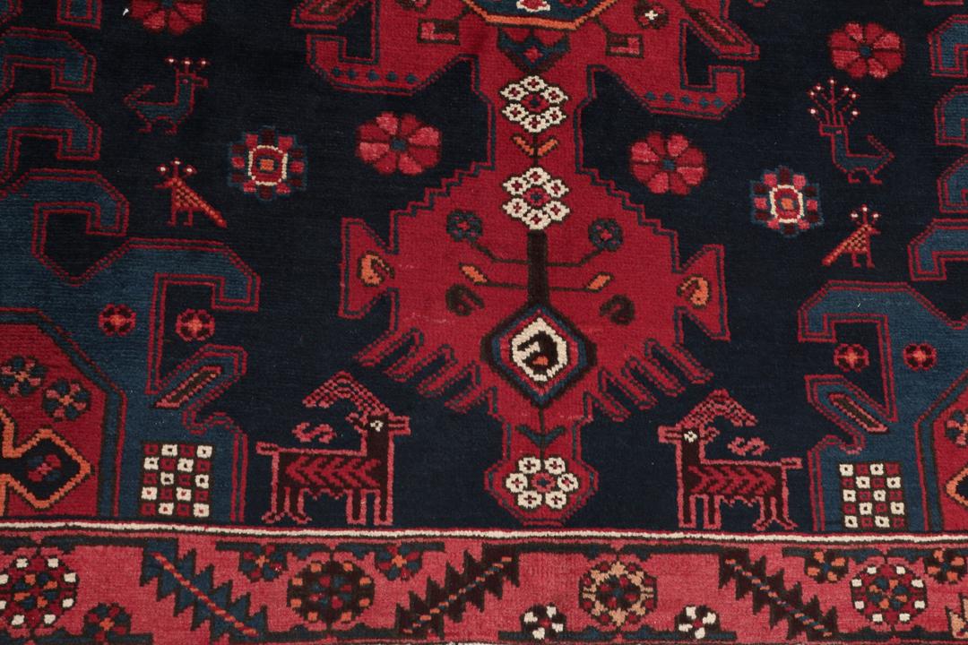 Een handgeknoopt Zanjan-tapijt uit het Midden-Oosten met een dieprood en zwart geometrisch ontwerp.
