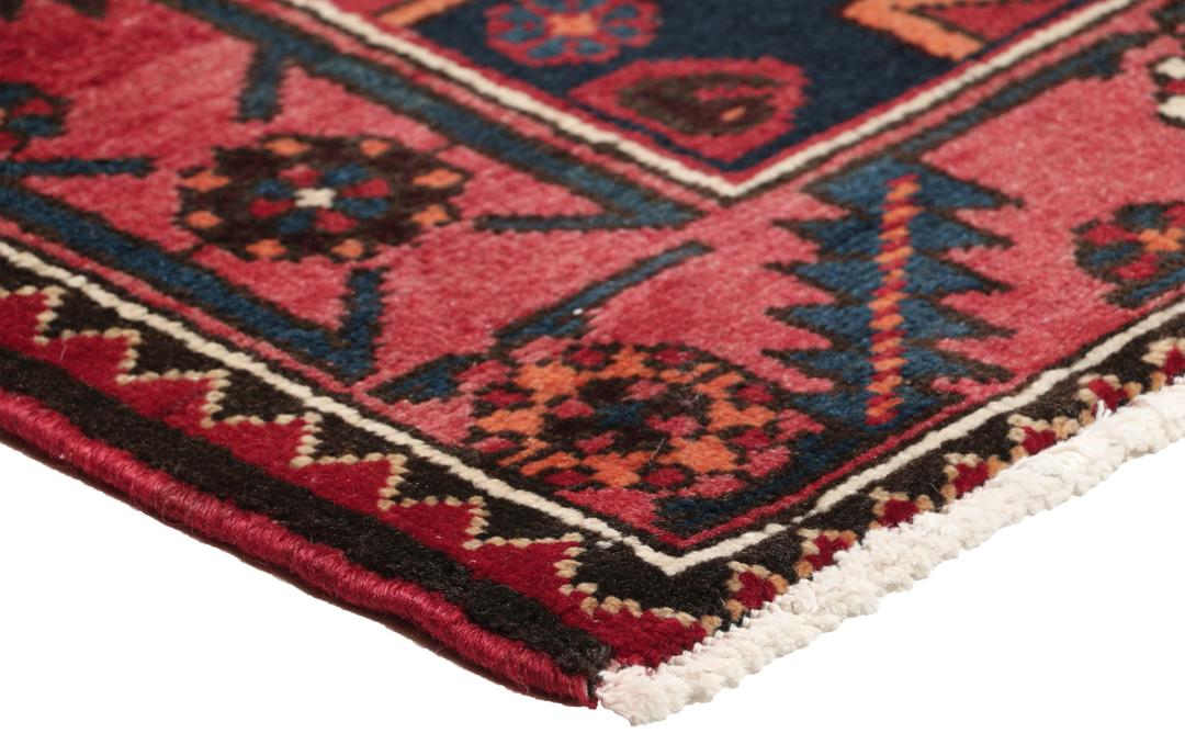 Een handgeknoopt Zanjan-tapijt uit het Midden-Oosten met een dieprood en zwart geometrisch ontwerp.