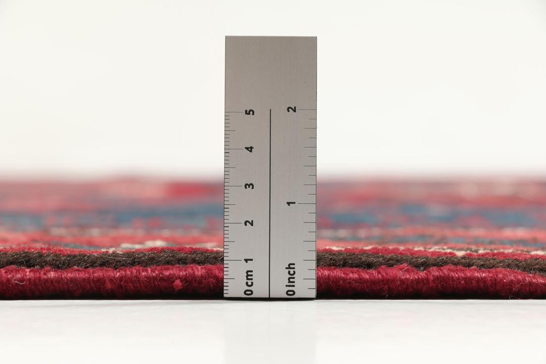 Een handgeknoopt Zanjan-tapijt uit het Midden-Oosten met een dieprood en zwart geometrisch ontwerp.