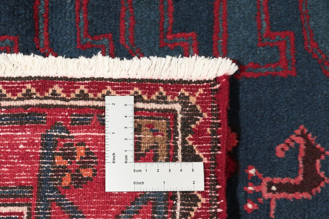 Een handgeknoopt Zanjan-tapijt uit het Midden-Oosten met een dieprood en zwart geometrisch ontwerp.