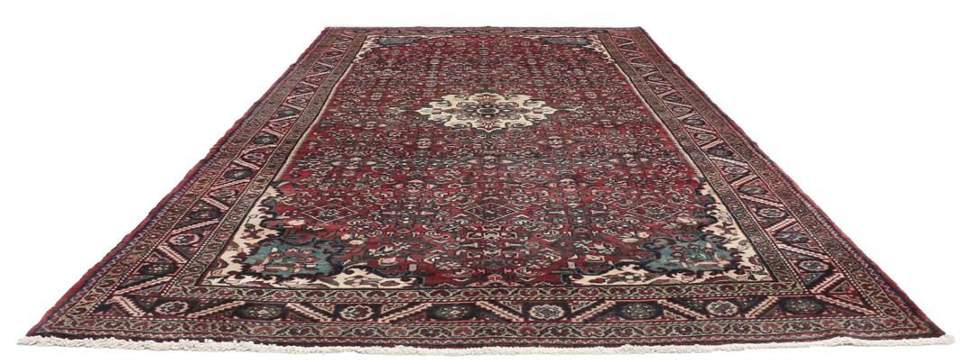 Handgeknoopt Nahavand-tapijt met een donkerrood veld en traditionele bloemmotieven.