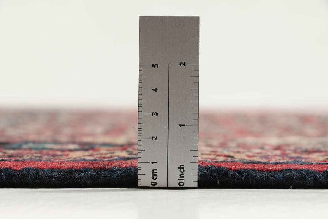 Handgeknoopt Nahavand-tapijt met een donkerrood veld en traditionele bloemmotieven.