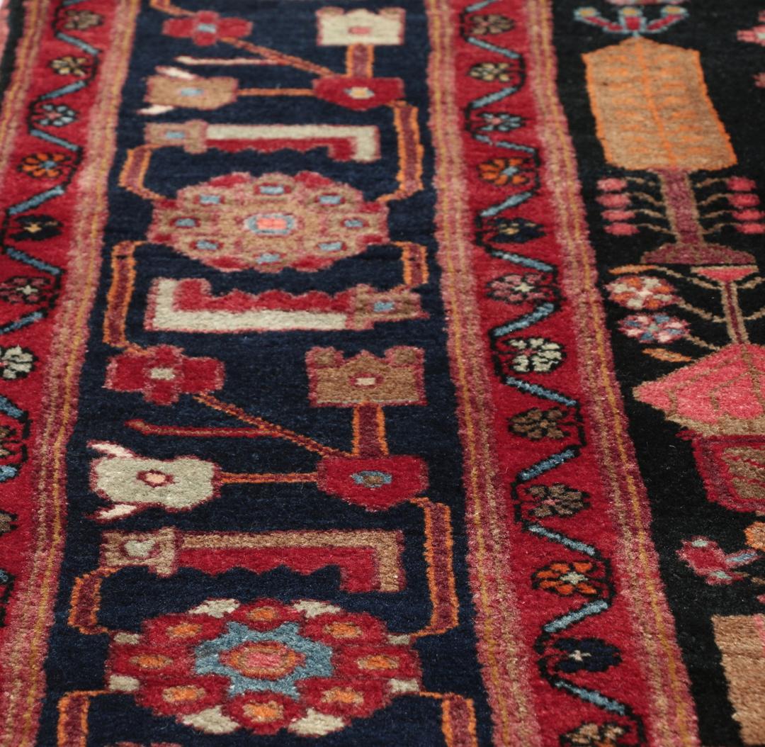 Handgeknoopt Kurdi Ghuchan-tapijt uit het Midden-Oosten met een veelkleurig tribaal patroon op een donker veld
