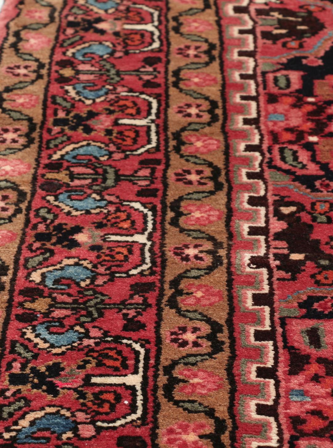 A rectangular hand-knotted Hamadan rug from the Middle East with a dark-red and black colour palette.